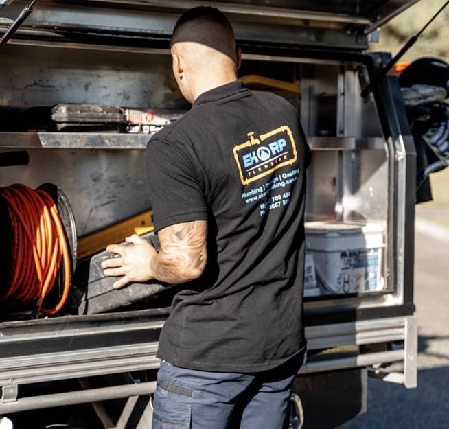 A plumber selecting equipment from the service vehicle